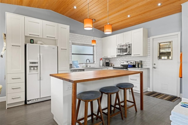 kitchen featuring white cabinets, wood ceiling, wood counters, stainless steel appliances, and backsplash