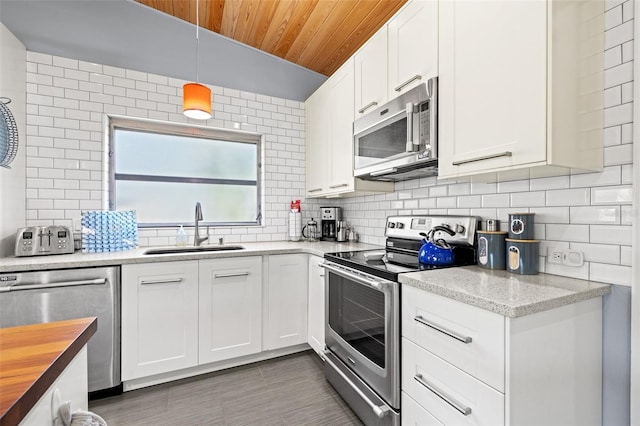 kitchen featuring stainless steel appliances, tasteful backsplash, a sink, and white cabinetry