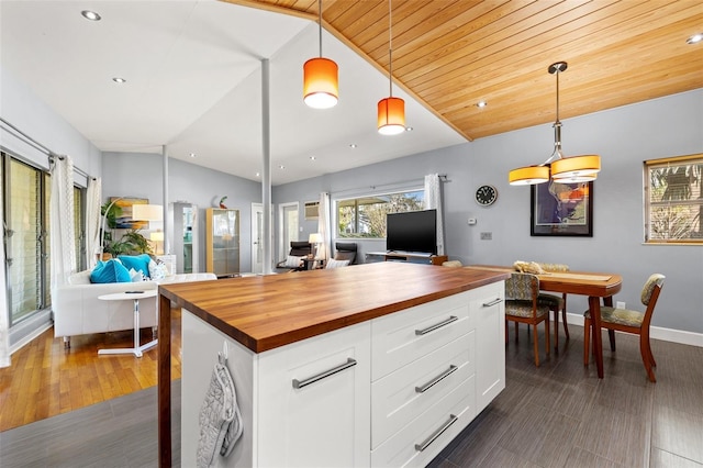 kitchen with open floor plan, wooden counters, and vaulted ceiling