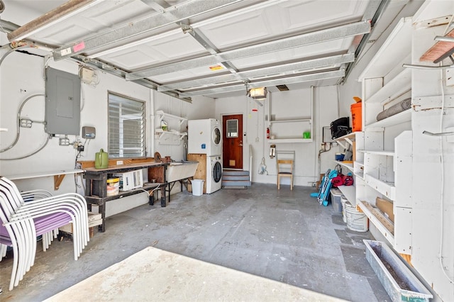 garage with a workshop area, stacked washer / dryer, electric panel, and a garage door opener