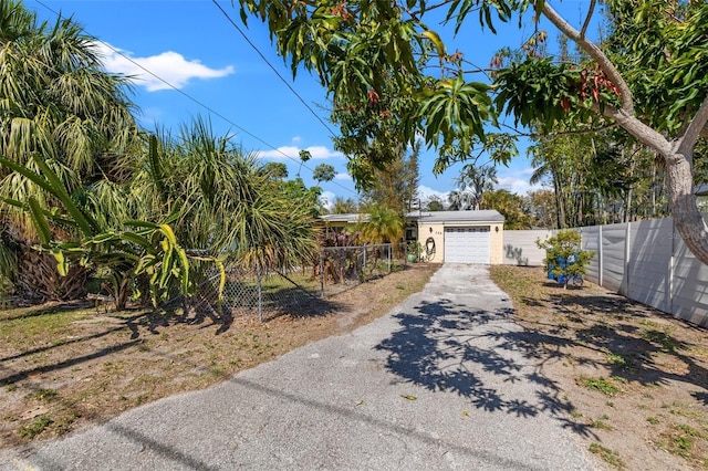 exterior space with a garage, fence, and aphalt driveway