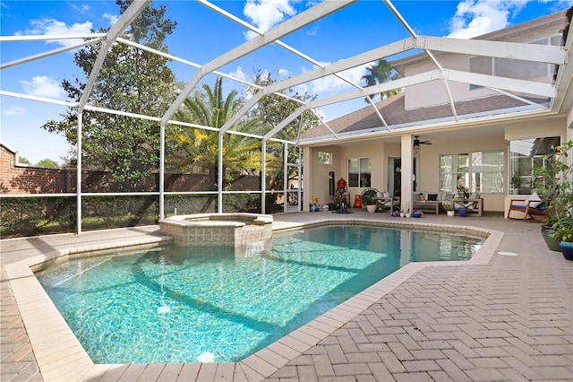 view of swimming pool with a pool with connected hot tub, a patio area, a lanai, and a ceiling fan