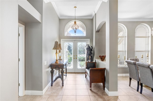 foyer with plenty of natural light, french doors, light tile patterned flooring, and ornamental molding