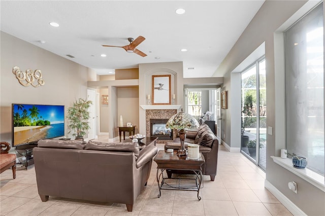 living area featuring a glass covered fireplace, light tile patterned floors, baseboards, and recessed lighting