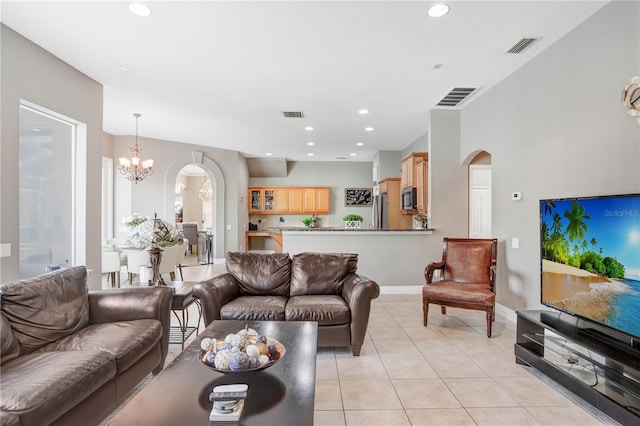 living area with arched walkways, light tile patterned floors, a chandelier, and visible vents