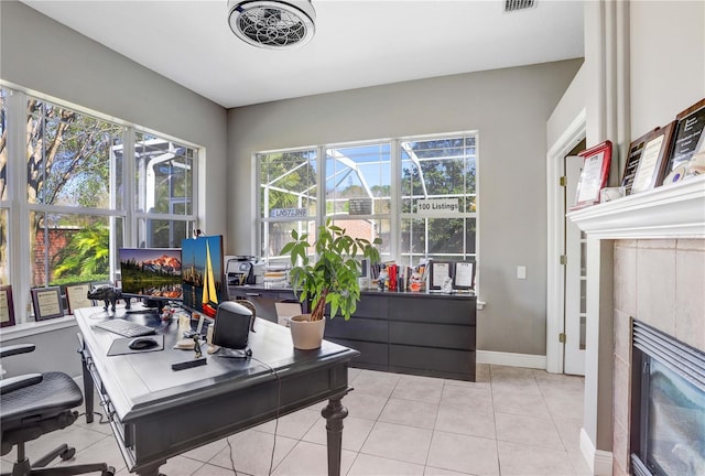 office area with baseboards, a tiled fireplace, and light tile patterned floors