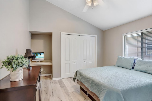 bedroom featuring light wood finished floors, lofted ceiling, a closet, ceiling fan, and baseboards