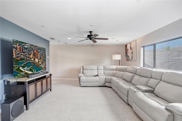 living room with a textured ceiling, light carpet, visible vents, a ceiling fan, and baseboards