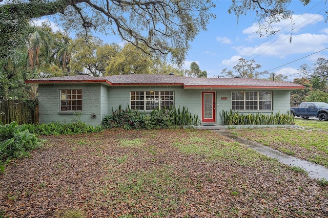 ranch-style home featuring fence