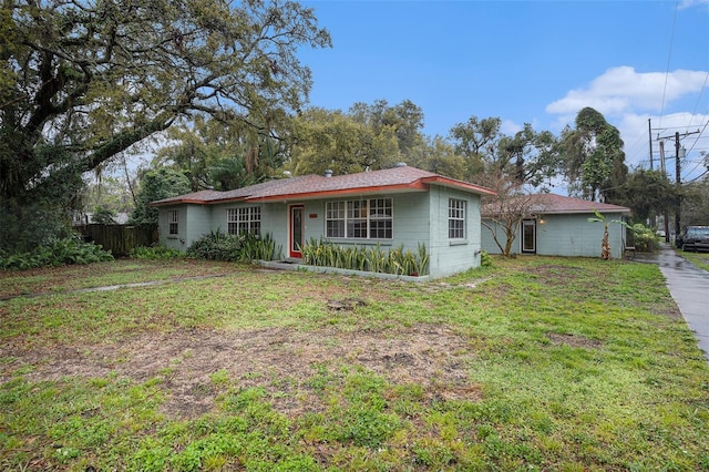 ranch-style house featuring fence and a front yard