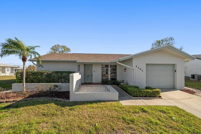 single story home with a garage, a front yard, concrete driveway, and stucco siding