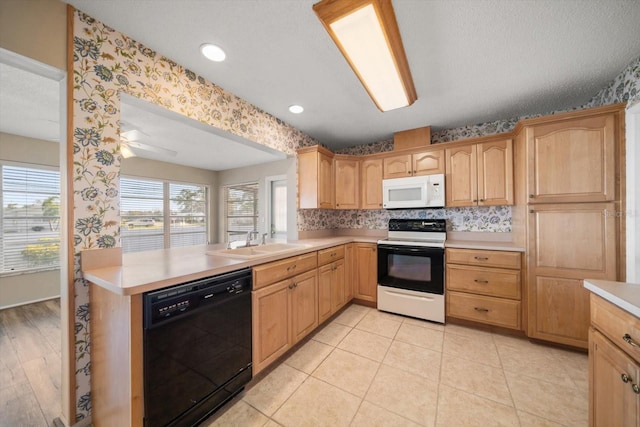 kitchen with electric range, dishwasher, white microwave, light countertops, and a sink