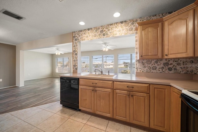 kitchen with plenty of natural light, black dishwasher, visible vents, a sink, and light tile patterned flooring