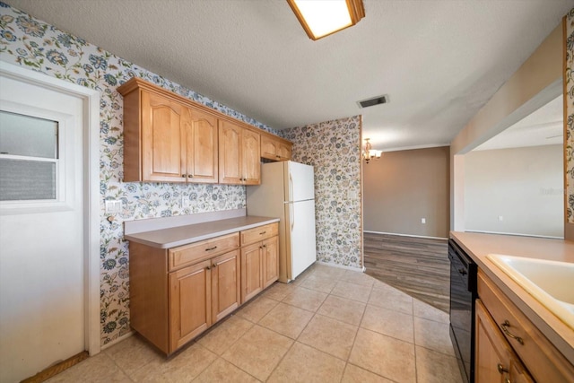 kitchen featuring freestanding refrigerator, black dishwasher, a textured ceiling, and wallpapered walls