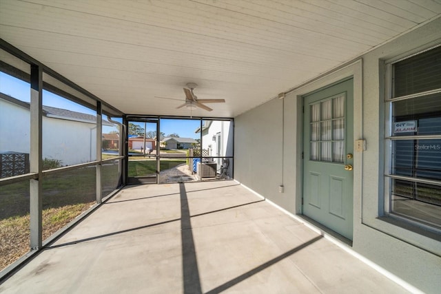 unfurnished sunroom with ceiling fan