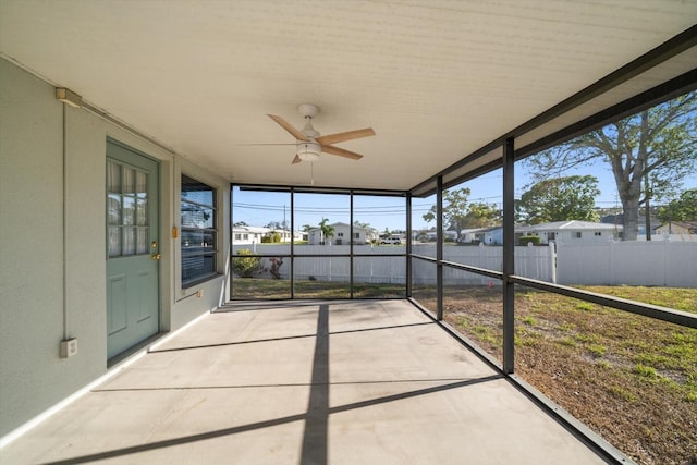 unfurnished sunroom with a wealth of natural light and ceiling fan