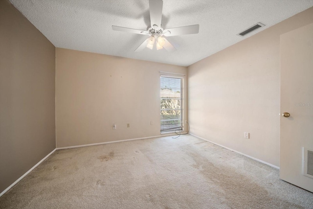 unfurnished room featuring ceiling fan, a textured ceiling, carpet, and visible vents