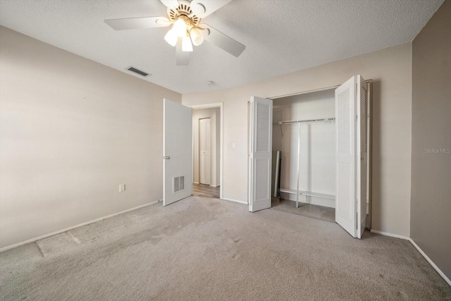 unfurnished bedroom with a textured ceiling, carpet flooring, and visible vents