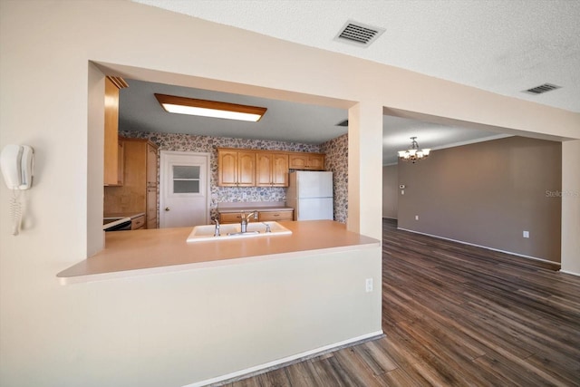 kitchen featuring wallpapered walls, visible vents, a sink, and freestanding refrigerator