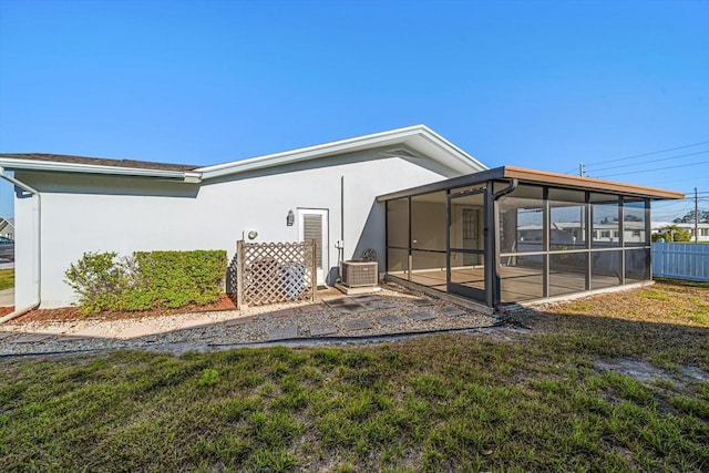 rear view of house with a patio, fence, a sunroom, and stucco siding