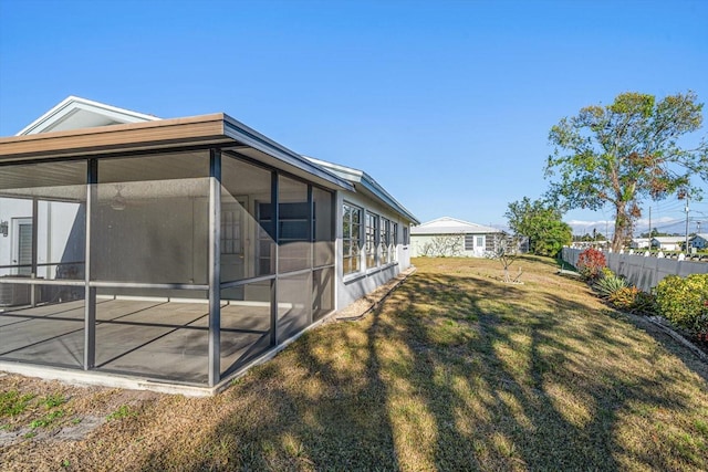 view of yard with a sunroom and fence