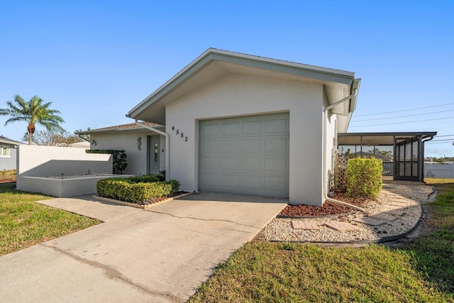 ranch-style house with concrete driveway, an attached garage, and stucco siding