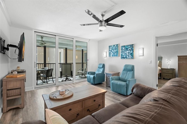 living room with a ceiling fan, floor to ceiling windows, crown molding, and wood finished floors