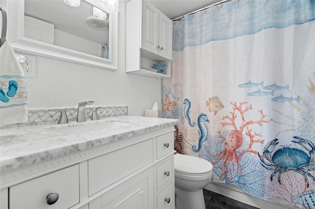 bathroom with curtained shower, vanity, and toilet