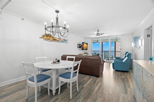 dining space with baseboards, wood finished floors, a wall of windows, crown molding, and ceiling fan with notable chandelier