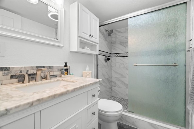 full bath featuring a stall shower, vanity, and toilet