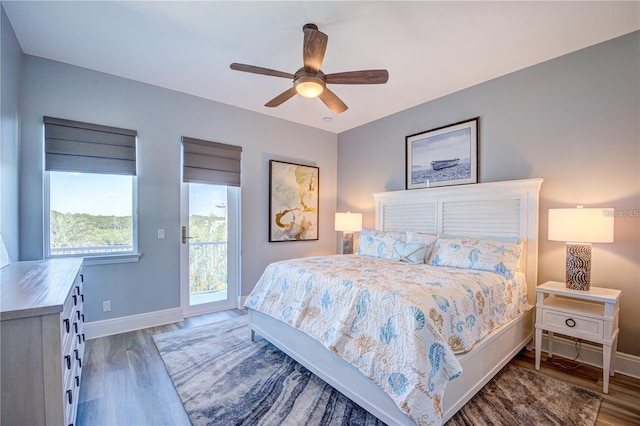 bedroom featuring baseboards, wood finished floors, a ceiling fan, and access to exterior