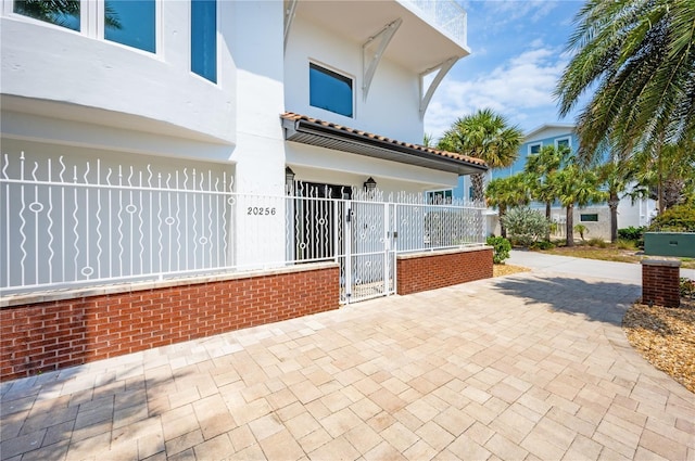 exterior space featuring a fenced front yard, a gate, and stucco siding