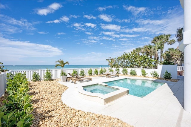 view of pool featuring a patio area, a fenced backyard, a pool with connected hot tub, and a water view