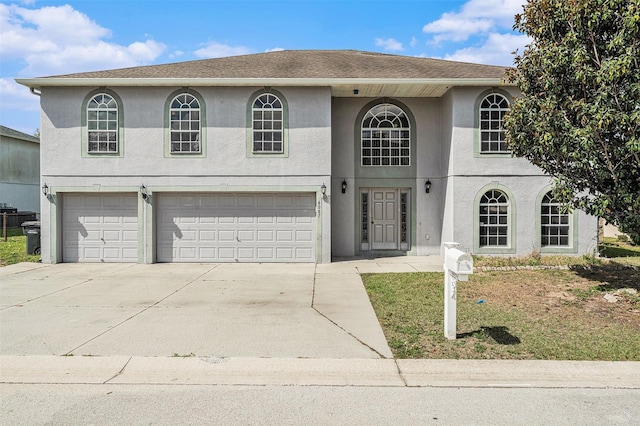 view of front of property with a garage, driveway, a shingled roof, and stucco siding