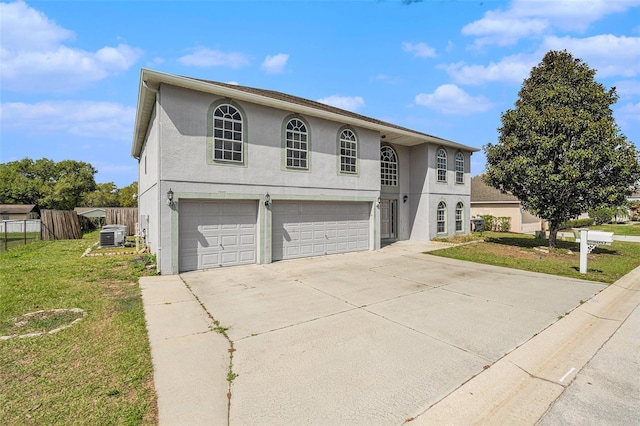 view of front of home featuring an attached garage, fence, concrete driveway, stucco siding, and a front yard