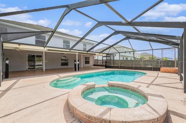 view of pool with glass enclosure, ceiling fan, fence, a patio area, and a pool with connected hot tub