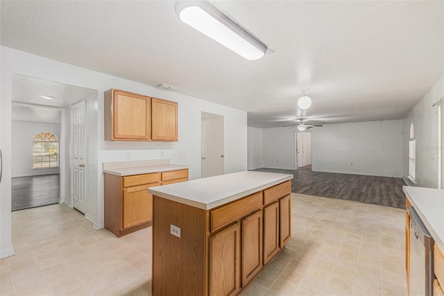 kitchen with visible vents, light countertops, a ceiling fan, and a center island