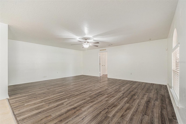 spare room with ceiling fan, a textured ceiling, and wood finished floors