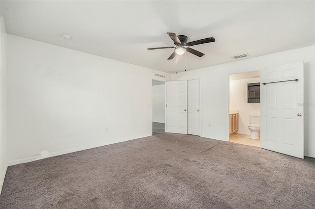 unfurnished bedroom featuring light carpet, ceiling fan, visible vents, and ensuite bathroom