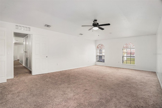 unfurnished room featuring ceiling fan, carpet flooring, visible vents, and baseboards