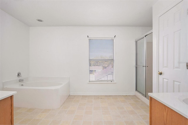 full bath featuring a garden tub, a shower stall, baseboards, and vanity