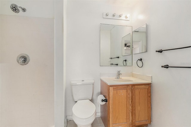 bathroom featuring a tile shower, vanity, and toilet