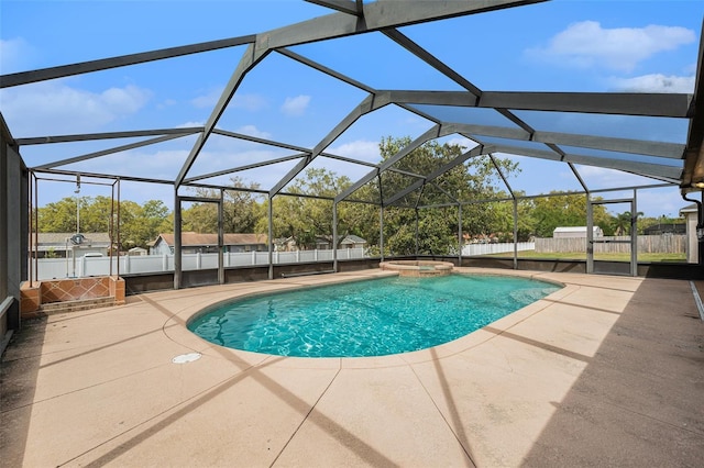 view of pool with glass enclosure, a pool with connected hot tub, fence, and a patio