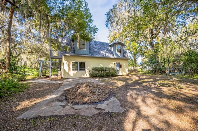 back of property with stairs and stucco siding