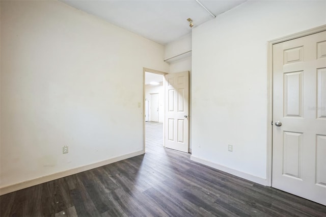 unfurnished bedroom with dark wood-style floors and baseboards