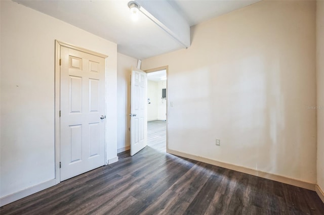 interior space featuring dark wood-type flooring and baseboards