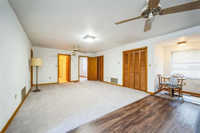 interior space featuring ceiling fan, wood finished floors, visible vents, and baseboards