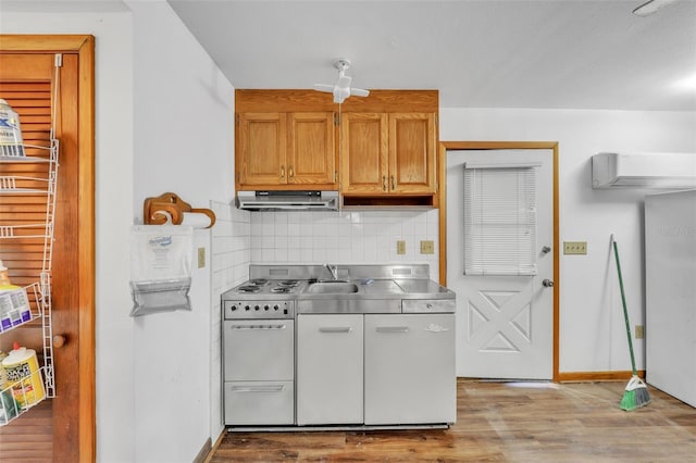 kitchen featuring stainless steel counters, backsplash, electric range oven, wood finished floors, and under cabinet range hood