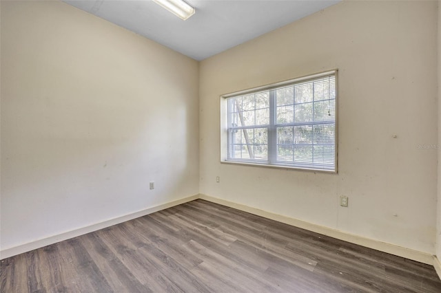 unfurnished room featuring baseboards and wood finished floors