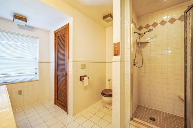 bathroom featuring a shower stall, toilet, and tile patterned floors